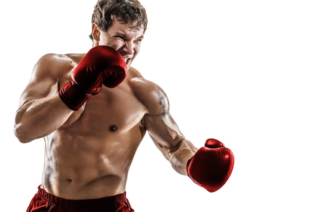 Half length of emotional male boxer who practicing left hook in red gloves on white background