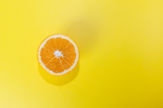 half an orange isolated on a yellow background