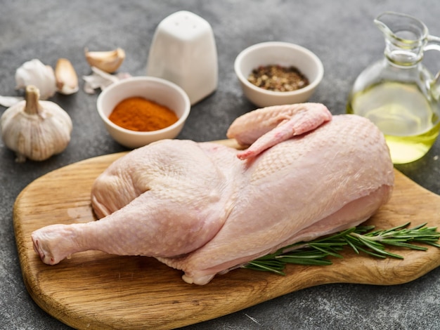 Half raw chicken Ingredients for cooking garlic vegetables on wooden rustic board uncooked chicken