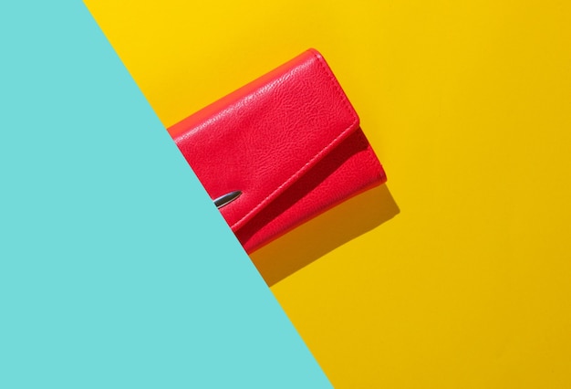 Half of Red leather wallet on blue yellow background. Top view