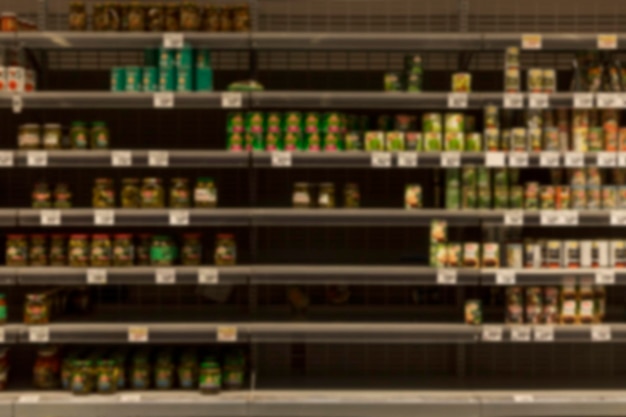 Halfempty shelves with canned food in the store Panic and crisis Blurred Front view