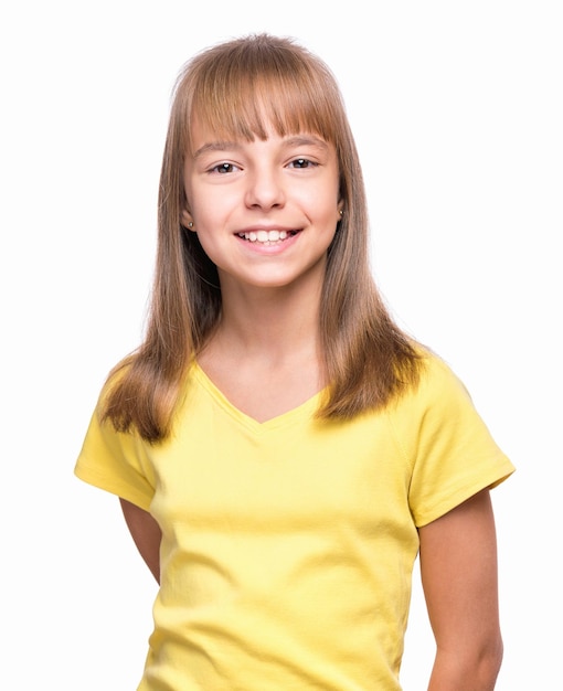 Halflength emotional portrait of caucasian girl wearing yellow tshirt Happy schoolgirl looking at camera Funny cute smiling child isolated on white background