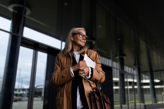 Halflength portrait of a strong elderly businesswoman at the entrance to the business center strong