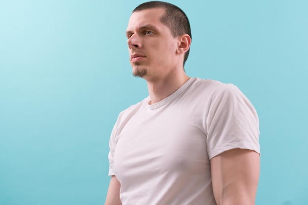 A halfside view of a man in a white tshirt on a blue background Modern One Studio White Young Casual Fashion Lifestyle Authority Concentration Hold Isolated