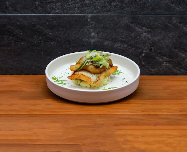 Photo halibut and leek with spring onion and coriander served in dish isolated on wooden table side view of italian fastfood