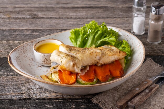 Halibut steak with baked vegetables on a plate