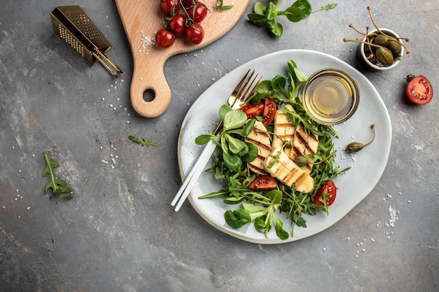 Halloumi cheese salad with arugula and tomatoes ketogenic paleo diet Delicious breakfast or snack Clean eating dieting vegan food concept top view