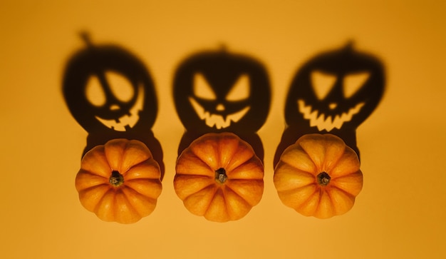 Halloween background concept. Jack O pumpkin angry face shadow. Spooky smiling shadow of an orange pumpkin lantern top view close up, Halloween party design