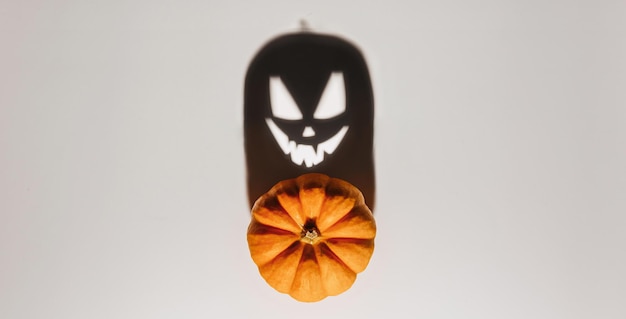 Halloween background concept Jack O pumpkin angry face shadow Spooky smiling shadow of an orange pumpkin lantern top view close up Halloween party design