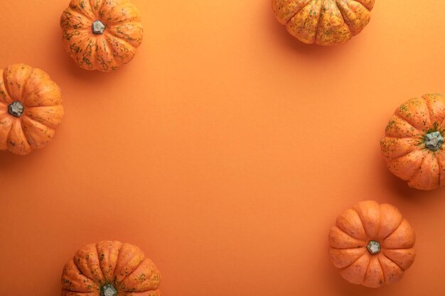 Halloween background Flock of black bats spider pumpkin and leaves for Halloween Black paper bat silhouettes on orange background Autumn decoration Halloween concept Top view