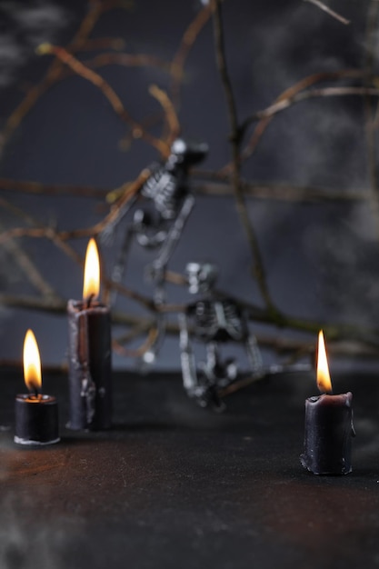 Halloween background with candles and skeletons in darkness