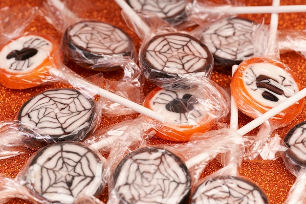 Halloween candy with spiders and webs and glitter background