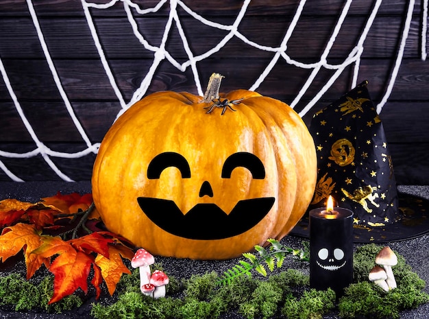 Photo halloween composition big pumpkin with scary face decorative pumpkins spiders and web candles