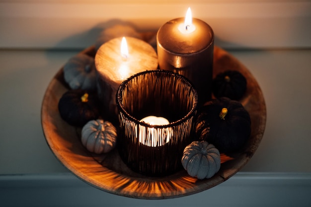 Halloween composition pumpkins with halloween black scents candles and black pumpkins in wooden