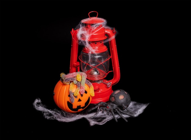 Halloween composition Red kerosene lamp and a pumpkin with a face on a black background