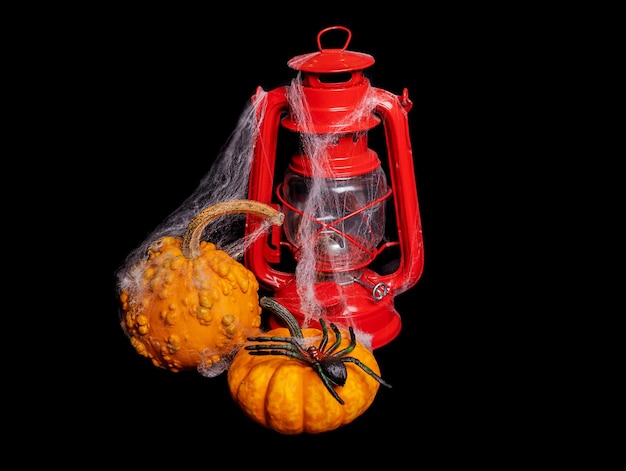 Halloween composition Red kerosene lamp and pumpkins on a black background