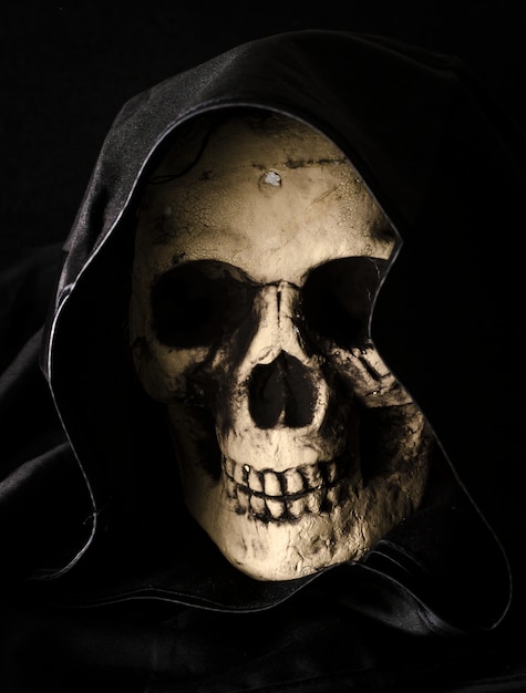 Halloween concept of scary skull head in black hood