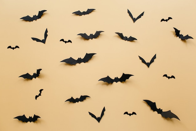 Halloween decorations with bats on pastel beige background halloween concept flat lay top view copy