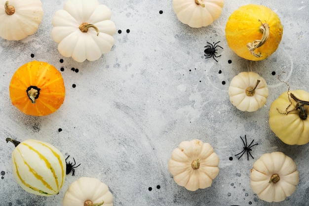 Halloween festive autumn background Autumn decor from pumpkins berries maple leaves and chestnuts on old rustic stone tiles backgrounds Concept of Thanksgiving day Halloween Top view copy space