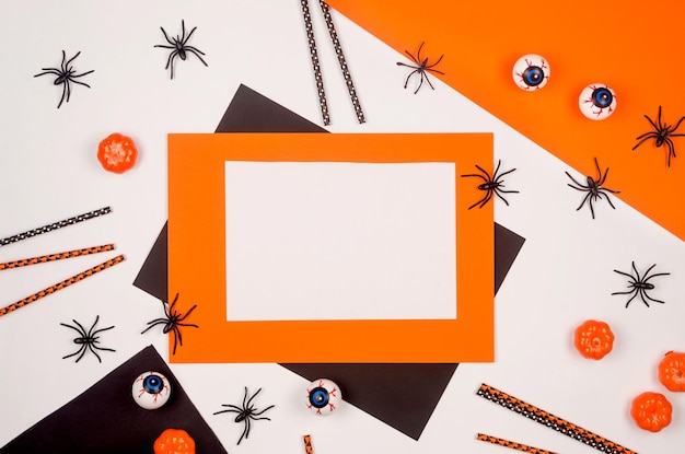 Halloween flat lay composition with pumpkins drink straws spiders confetti treat