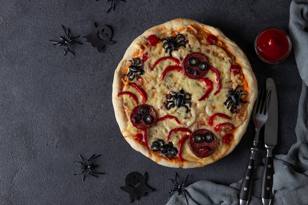 Halloween funny pizza with spiders Creative idea for Halloween pizza on dark gray background Top view