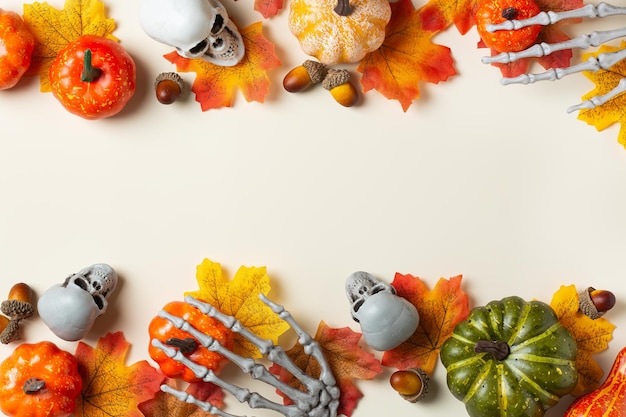 Halloween greeting card with pumpkin skulls bony hands and leaves