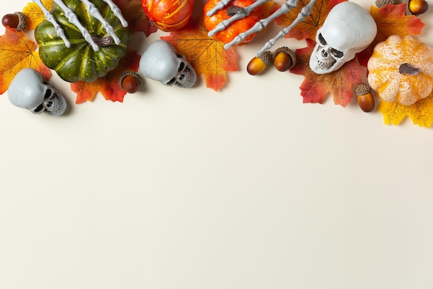 Halloween greeting card with pumpkin skulls bony hands and leaves