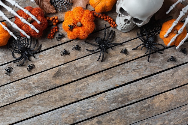 Halloween greeting card with pumpkin skulls bony hands and leaves