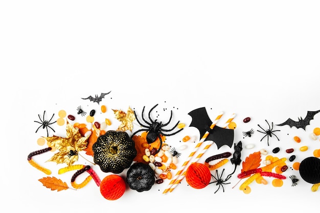 Photo halloween holiday background with colorful candy, bats, spiders, pumpkins and decorations. flat lay. view from above