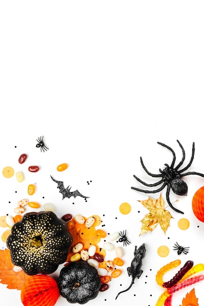 Halloween holiday background with colorful candy, bats, spiders, pumpkins and decorations. Flat lay. View from above