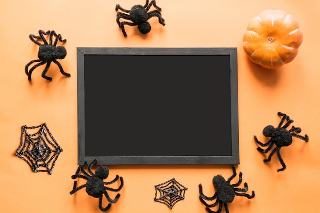 Halloween holiday blank with party decor black spiders web on orange Flat lay top view Space for text