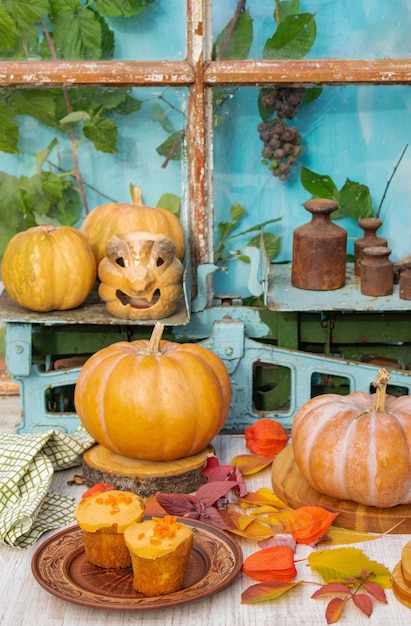 Halloween holiday composition orange pumpkins and cakes on the table