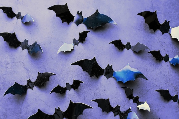 Halloween holiday concept. Old stone table in a shape of bats. Halloween paper decorations on dark background. Moon toy.