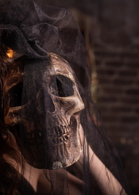 Halloween Human skull in girl's hands Under a black veil