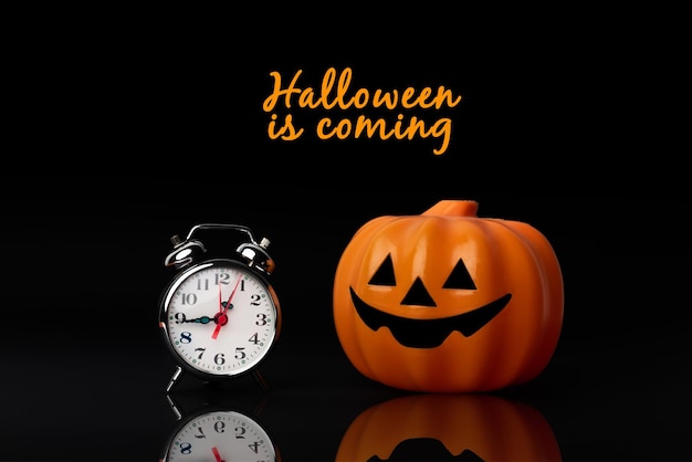 Halloween is coming Toy pumpkin next to a clock Holidays Time to dress up as a witch or zombie