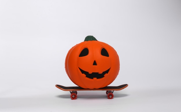 Halloween jack pumpkin ride on skateboard isolated on white background Halloween concept