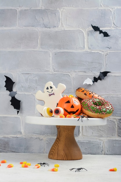 Halloween kids party table with candy corns, ginger cookies and spooky donuts