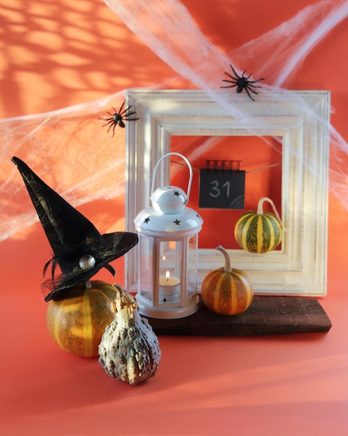 Halloween, a lantern with a burning candle, pumpkins, a witch's hat cobwebs with spiders