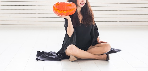 Halloween and masquerade concept - Beautiful close-up young woman posing with Pumpkin Jack-o'-lantern