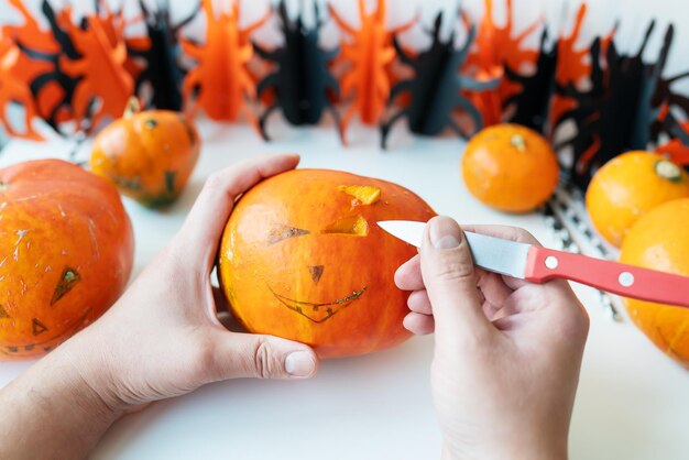 Halloween October 31st A man cuts the face of a pumpkin with a knife View from above