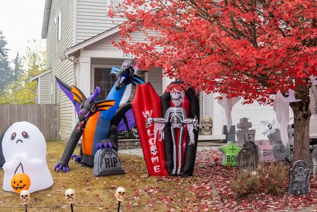 Halloween outdoor decorations with inflatable figures of dragon, skeleton in coffin and sculls