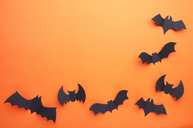 Halloween paper bats on orange background. Halloween 