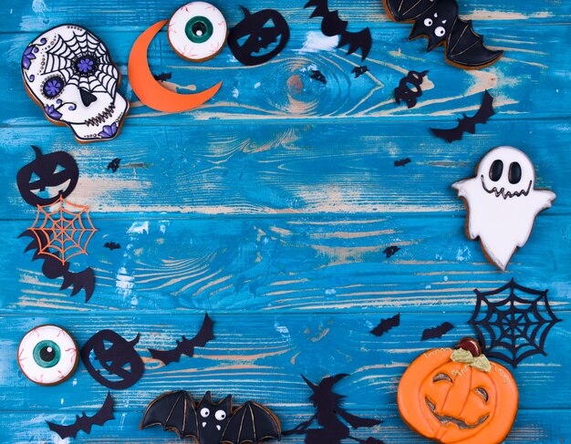 Halloween party content. Halloween gingerbread cookies on the blue wood background.