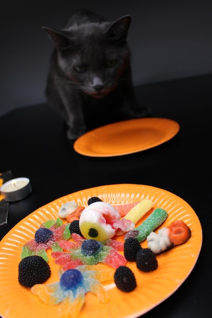 Halloween party Sweets come out of a fallen jar on top of some orange and black napkins