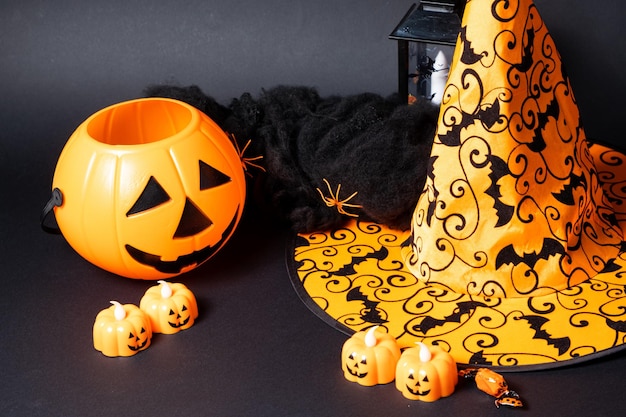 Halloween postcard pumpkins and a hat on a black background