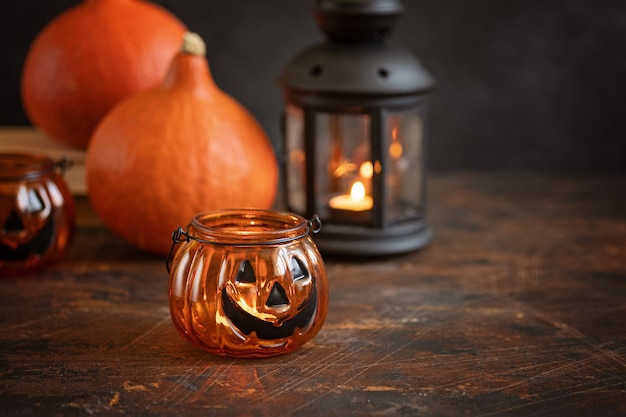 Halloween pumpkin head jack glass lantern. Halloween decoration on wooden table background, selective focus Copy space for text - Image