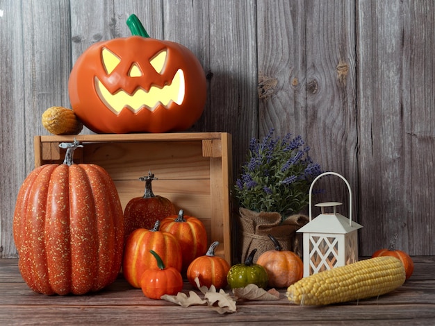 Halloween pumpkin head lantern with candles an pumpkin on wooden background