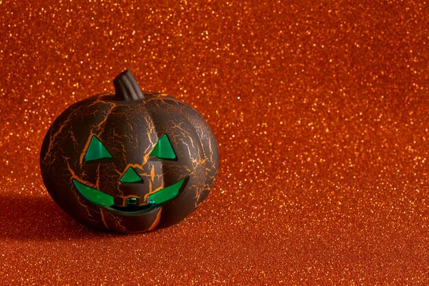 Halloween pumpkin illuminated with green light on bright orange background