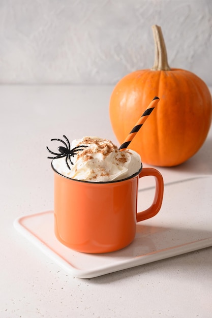 Halloween pumpkin latte coffee with whipped cream decorated spiders