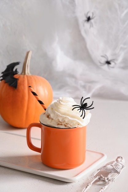 Halloween pumpkin latte coffee with whipped cream decorated spiders